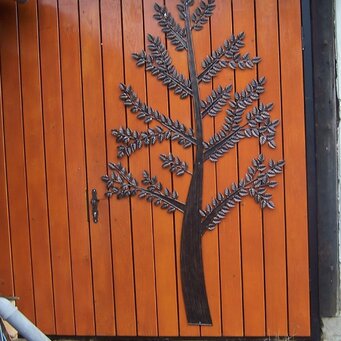 Brána obbložená drevom z dekoračným dyzajnom,strom